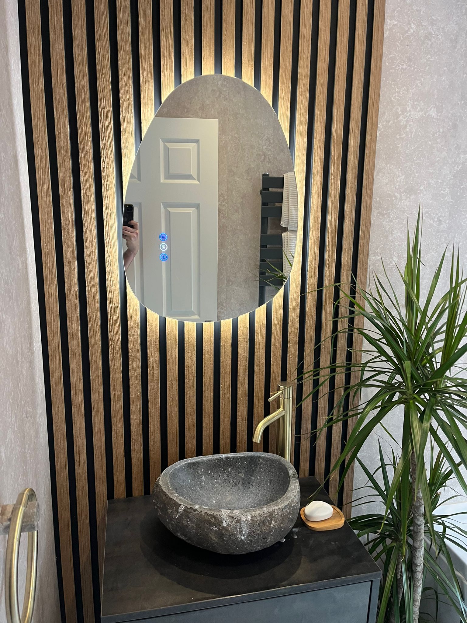 Oak-slat feature wall with stone basin